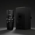 Lattafa Asad Elixir Lattafa 100ml for Men — Botol wangian hitam legam dengan reben perak berkilat dan kotak hitam bersebelahan di atas latar belakang gelap