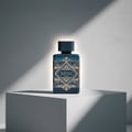 Lattafa Badee Al Oud — Blue fragrance bottle with gold geometric label on a white pedestal, dramatic lighting.