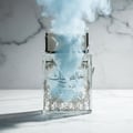 Lattafa Pure Musk by Lattafa (Khalis Musk) 100ml EDP — A clear glass perfume bottle with ornate gold detailing, cracked and emitting blue smoke.