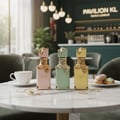 Lattafa Eclaire Pistache — Three perfume bottles in pastel colors with gold accents on a marble table with a coffee cup and