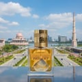 Lattafa Fire On Ice by Lattafa 100ml EDP Unisex — Botol wangian kaca jernih berisi cecair keemasan, dengan penutup emas berukir tulisan. Latar belakang bandar moden dengan bangunan ikonik dan langit biru berawan.