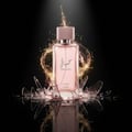 Lattafa Hayaati Florence by Lattafa 100ml EDP Women — Pink perfume bottle with gold splash effect and shattered glass fragments on a black background.