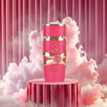 Lattafa Yara Candy by Lattafa 100ml EDP Women — Botol minyak wangi merah jambu dengan perincian emas, dipamerkan di atas pedestal berlekuk merah jambu berlatar belakang langsir merah jambu dan awan putih gebu.