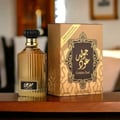 Lattafa Golden Oud by Lattafa Asdaaf — Gold fluted perfume bottle and matching box with ornate design on a wooden surface.