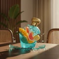 Lattafa Opulent Dubai by Lattafa Perfume 100ml (Unisex) — A shattered turquoise perfume bottle with a gold cap, spilling fruit slices (mango, grapefruit, lemon) and liquid onto a wooden table, with chairs and a plant in the background.