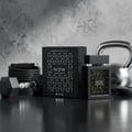 Rave Now by Rave Perfume Lattafa 100ml For Man — Black perfume bottle and box with geometric pattern, next to a dumbbell, jump rope, and kettlebell on a dark surface.