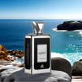 Lattafa Ejaazi Intensive – Silver perfume bottle on rocks by the ocean with blue sky