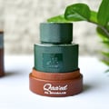 Lattafa Qaaed Al Shabaab by Lattafa 100ml for Men — Green textured bottle with Arabic script and gold accents, on a brown base, with a green leaf in the background.