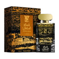 Lattafa Qasaed Al Sultan — Black and gold patterned box with a cityscape illustration, next to a clear glass perfume bottle with a gold cap and matching black and gold label.