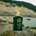 Lattafa Safeer by Lattafa Al Noble 100ml EDP — Green velvet bottle with a gold deer head cap, set on a rock with a blurred water and hill background.