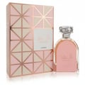 Lattafa Shahd by Lattafa Perfumes 100 ml Women — Pink perfume bottle and matching geometric patterned box with rose gold accents, set against a white background.