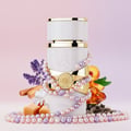 Lattafa Yara Moi by Lattafa 100ml EDP Women — White perfume bottle with gold accents, wrapped in pearl necklaces, surrounded by lavender, cinnamon sticks, jasmine, caramel, peach, and amber.
