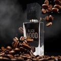 Maison Alhambra Black Wood 60ml EDP for Men — A black glass perfume bottle with a textured black cap, surrounded by scattered coffee beans and wisps of smoke against a dark background.
