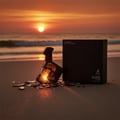 Maison Alhambra Luxe Street — Unisex Eau de Parfum bottle and box on a beach at sunset, with shattered glass fragments around the bottle.