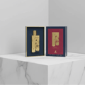 Maison Alhambra Renee Carmine EDP 100 ml — Gold bottle and box displayed on a marble surface with a grey background.