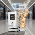 Maison Alhambra Ebene by Maison Alhambra Perfume 90 ml EDP — A white box and a glass perfume bottle with golden flames erupting from the top, set against a blurred mall background. Scent notes of Vanilla, Amber, Benzoin, and Musk are listed.