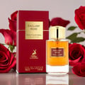 Maison Alhambra Exclusif Rose — Red box and gold-capped perfume bottle with red roses in the background.