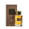 Maison Alhambra Exclusif Tabac – A brown box and a clear glass perfume bottle with golden cap and amber liquid, set against a white background.