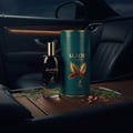 Maison Alhambra Glacier Bold by Maison Alhambra 100ml EDP — Black perfume bottle and teal cylindrical box with gold accents, placed on a wooden surface inside a car.