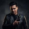 Maison Alhambra Glacier Le Noir by Maison Alhambra 100ml Men — Man in a black leather jacket holding a black perfume bottle with a gold cap and collar, dark smoky background.
