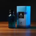 Maison Alhambra Jean Lowe Azure by Maison Alhambra EDP 100 ml — A blue glass perfume bottle with a black cap stands next to its blue and white patterned box on a wooden surface, against a dark background.