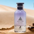 Maison Alhambra Jean Lowe Matiere — A clear glass perfume bottle with purple liquid, set on sand dunes with a blurred desert background.