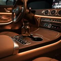 Maison Alhambra Jean Lowe Noir Maison Alhambra 100ml EDP — Amber glass perfume bottle with black cap placed in a car's center console, illuminated by ambient lighting.