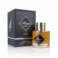 Maison Alhambra Kismet Magic by Maison Alhambra 100ml EDP Unisex — Black textured box with gold geometric pattern and feather detail, next to a clear glass perfume bottle with amber liquid and gold ribbed cap.