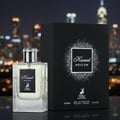 Maison Alhambra Kismet Moscow EDP — A clear glass perfume bottle with a silver ribbed cap and a black label featuring a deer logo, placed next to its black product box with a glittery square design, set against a blurred city skyline at night.
