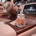 Maison Alhambra La Vita Maison Alhambra 100ml EDP Women — Botol minyak wangi kaca jernih bertutup kristal faset diletakkan di konsol tengah kereta mewah, dengan pencahayaan ambien lembut.