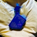 Maison Alhambra Luxe Nightlife by Maison Alhambra Unisex 100 ml — Blue glass perfume bottle with gold dot pattern and deer logo, resting on a golden satin fabric.