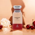 Maison Alhambra Forbidden Love by Maison Alhambra 80ml EDP Women — Botol minyak wangi kaca jernih dengan penutup berjalur perak dan aksen merah, tertulis 'FORBIDDEN LOVE EAU DE PARFUM' dan logo rusa. Diletakkan di atas permukaan memantul dengan bunga ros putih dan buah ceri.