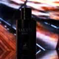 Maison Alhambra Salvo Elixir — Botol minyak wangi hitam dengan tulisan 'SALVO ELIXIR' dan logo rusa, berlatar belakang abstrak berwarna-warni yang kabur.