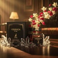 Maison Alhambra Versencia Noir — Black perfume box and bottle with crystals and floating red and white flowers.