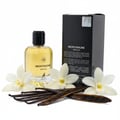 Maison Alhambra Montaigne Vanille — A clear glass perfume bottle with a black cap, surrounded by white vanilla flowers and dark vanilla pods, with the product box in the background.