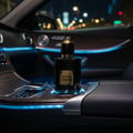 Maison Alhambra Black Origami 100ml EDP — Botol minyak wangi hitam bertutup emas dan label, diletakkan dalam pemegang cawan kereta dengan lampu biru ambien pada waktu malam.