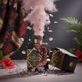 Maison Alhambra Infini Oud by Maison Alhambra Man 100ml EDP — A shattered perfume bottle with pink smoke and petals exploding outwards, set against a dark background with fabric and foliage.