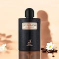 Maison Alhambra Opera Noir by Maison Alhambra 100ml EDP — Black textured bottle with gold label, deer logo, and black cap, set against a soft peach background with shadows and white flowers.