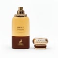 Maison Alhambra Smoky Touch by Maison Alhambra 80ml EDP — A golden-brown perfume bottle with a gold cap, standing next to its detached gold cap on a white background.