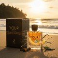 Maison Alhambra Your Touch Man by Maison Alhambra – 100 ml perfume bottle and box on a beach at sunset, with a slice of melon and lavender sprigs.
