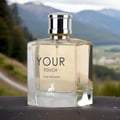 Maison Alhambra Your Touch Women by Maison Alhambra – 100 ml perfume bottle with a silver cap, featuring the text 'YOUR TOUCH FOR WOMEN' and a deer logo, set against a blurred mountainous landscape.