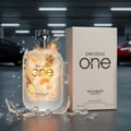 Pendora One Pendora Scents For Him – 100 ml for Men, frosted glass bottle with pineapple and orange slices, shattered glass fragments, and a white product box in a parking garage setting