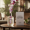 Pendora One Pendora Scents For Him – A frosted glass perfume bottle with flowers erupting from the top, next to its white product box on a wooden table.