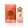 Paris Corner Khair Fusion — Botol minyak wangi gradien merah jambu dengan penutup emas berhias di sebelah kotak bercorak merah dan emas yang sepadan, terasing di atas putih.