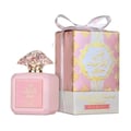 Ard Al Zaafaran Shams Al Emarat Khususi Pink Blush 100ml — Botol minyak wangi merah jambu dengan penutup jernih berfaset, bersebelahan kotak hadiah corak merah jambu dan emasnya yang diikat dengan reben putih.