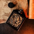 Rayhaan Rayhaan Lion Powerful for Man 100ml — Black perfume bottle with a detailed gold lion emblem on the front, cap to the side on textured paper background.