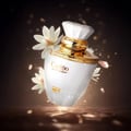 Rue Broca Carino White Pour Femme 100ml EDP — White perfume bottle with gold accents, adorned with white flowers and sparkling golden lights against a dark background.