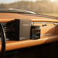 Rue Broca Theoreme Matrix by Rue Broca – 90 ml for Men, a dark glass perfume bottle and its black box placed on the dashboard of a vintage car.