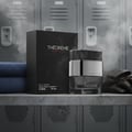 Rue Broca Theoreme Matrix by Rue Broca – 90 ml for Men, a black box and glass bottle with silver accents, placed on a shelf in a locker room setting with folded blue towels and black gloves.