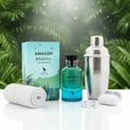 Volare Amazon Rainfall by Volare 100ml EDP Men — A turquoise and blue perfume bottle with a silver shaker, rolled white towel, and white earbuds on a reflective surface, set against a lush green jungle background.